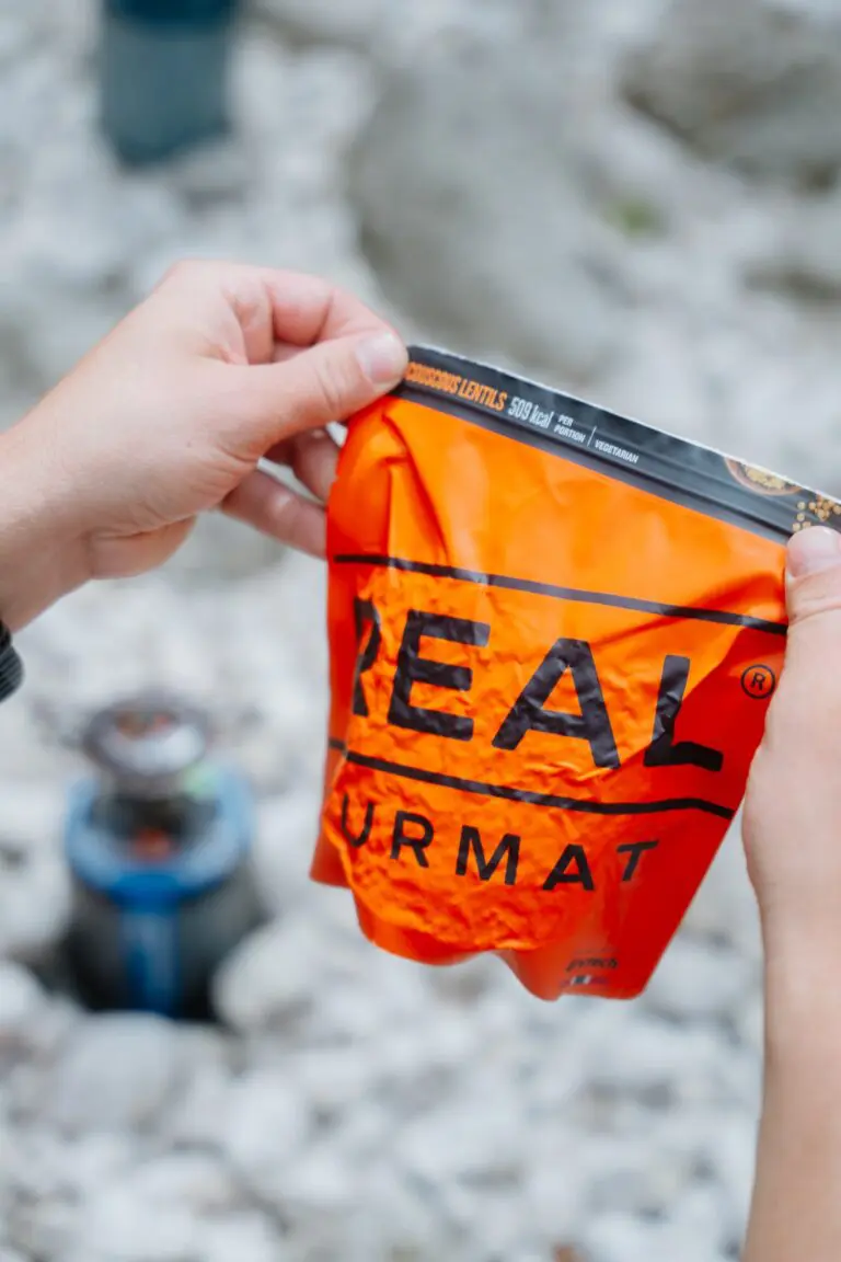 hands opening a Real Turmat meal pouch outdoors