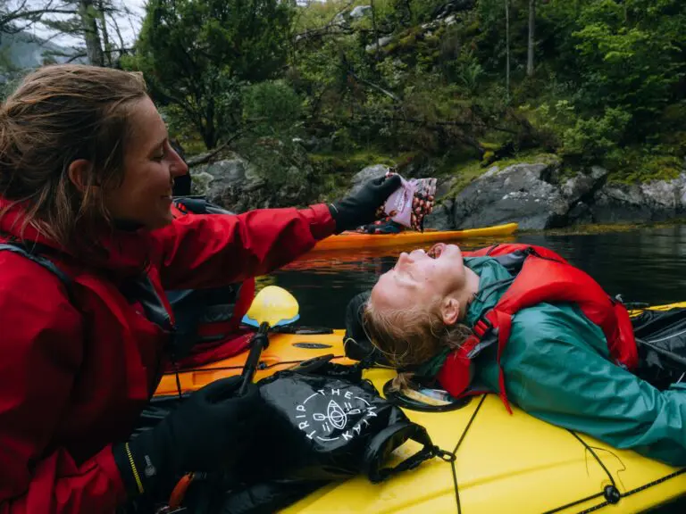deux femmes en kayak, l’une donnant des en-cas à l’autre