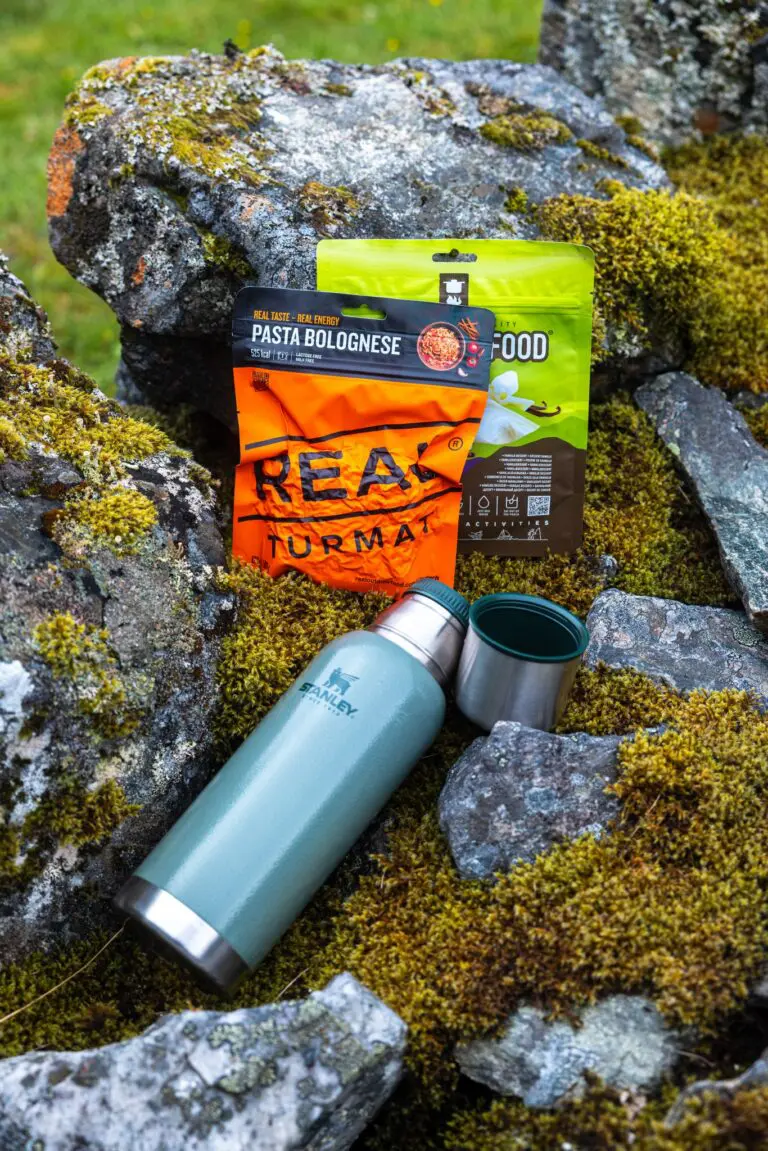 repas de randonnée et thermos sur des rochers moussus
