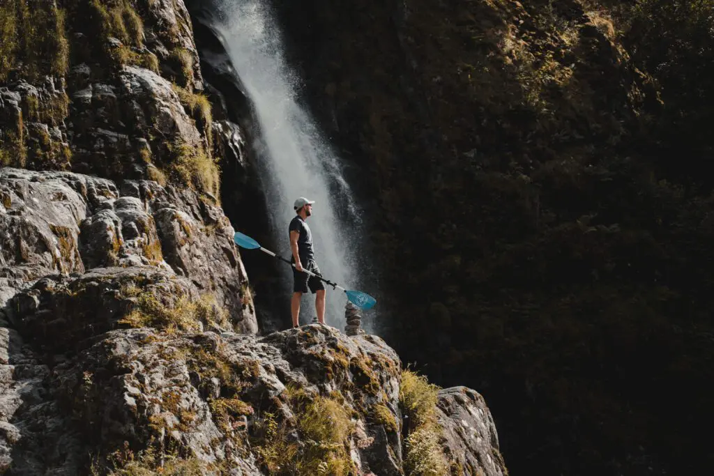 Hommes avec pagaie à côté d'une cascade - Kayak - fjord de Norvège - randonnée en Norvège - kayaking - depuis l'aéroport de Bruxelles.