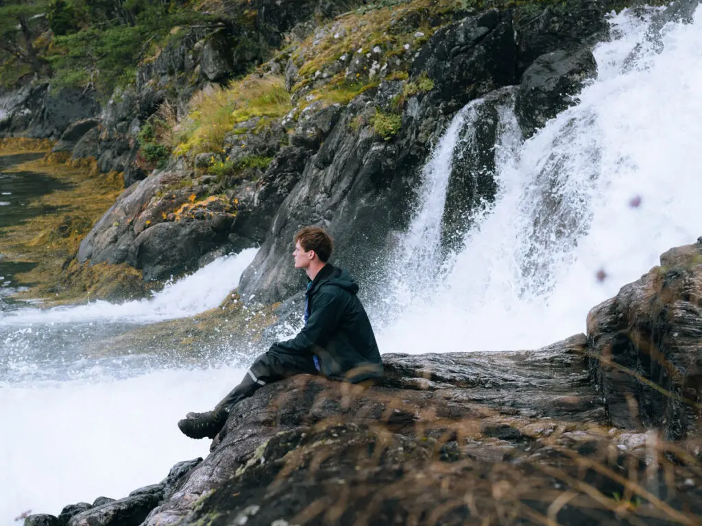 Men staring next to waterfall