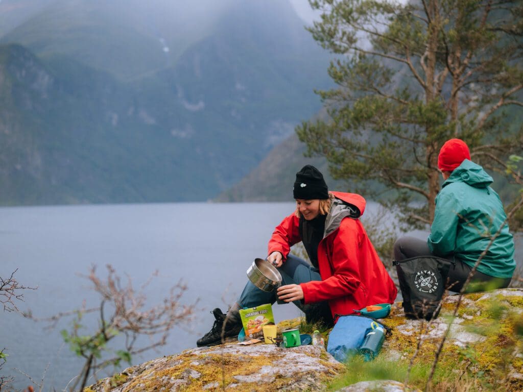 Woman boiling water for coffee and a foodpack - Kajakken - Noorwegen fjord - wandelen in Noorwegen - kayaking - vanaf luchthaven Brussel